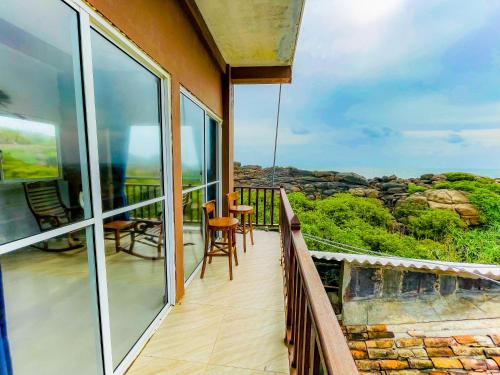 a balcony with chairs and a view of the ocean at Blowhole Unawatuna in Unawatuna