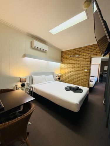 a bedroom with a large bed and a desk and a table at Motel St Arnaud in Saint Arnaud