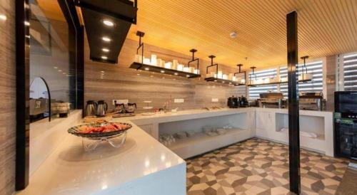 a kitchen with a bowl of fruit on a counter at Echarm Hotel Fuzhou Sanfang Qixiang East Street Metro Station in Fuzhou