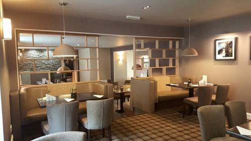 a restaurant with a table and chairs and a dining room at The Fairburn Hotel in Mauchline