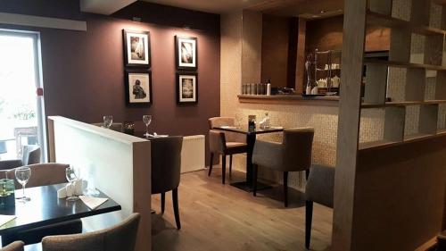 a restaurant with a bar and tables and chairs at The Fairburn Hotel in Mauchline