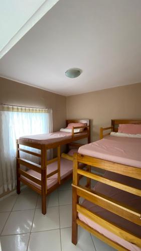 a room with three bunk beds and a table at Hostel Tiquinho in Belém