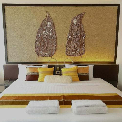 a bedroom with a large bed with three pillows at Stay Kata in Kata Beach