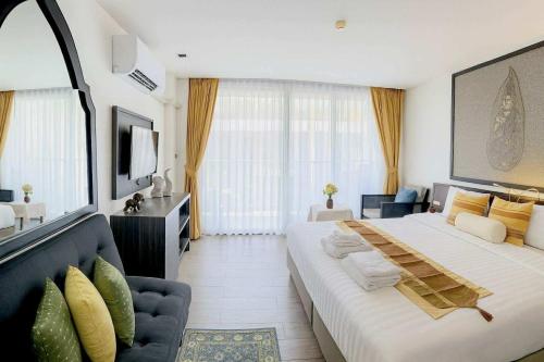 カタビーチにあるStay Kataの大きなベッドとソファのあるホテルの部屋