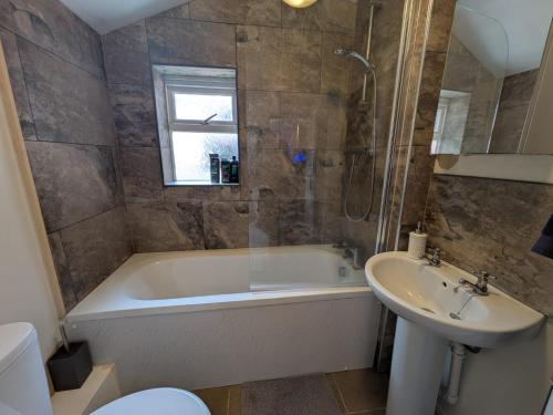 un baño con bañera y lavabo en Grantham Town Centre, en Lincolnshire
