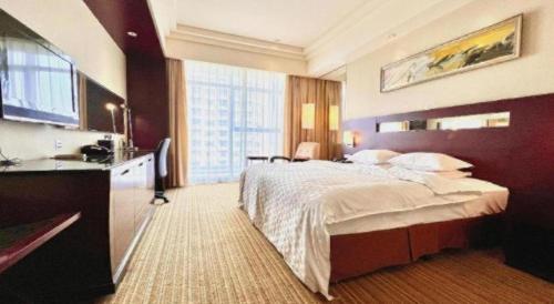 HaizhouにあるRamada Plaza by Wyndham Lianyungangの大きなベッドとキッチンが備わるホテルルームです。