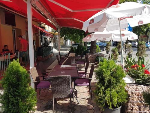 un restaurante al aire libre con mesas, sillas y sombrillas en Club Haus 502 Kalocsa en Kalocsa