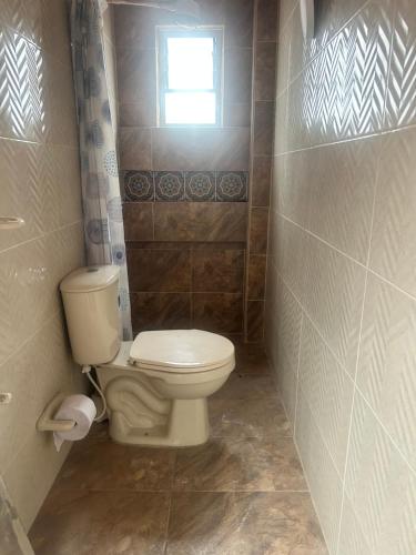 une petite salle de bain avec toilettes et fenêtre dans l'établissement Tranquilo y bonito, à Bogotá