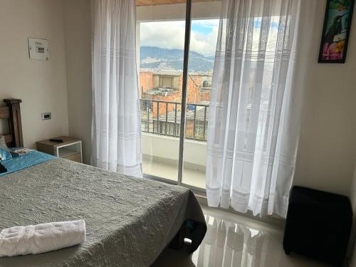 une chambre avec un lit et une grande fenêtre dans l'établissement Tranquilo y bonito, à Bogotá