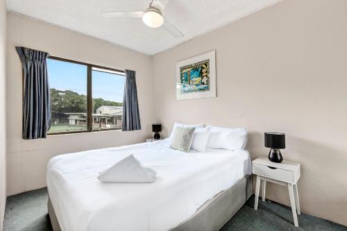a bedroom with a large white bed and a window at Beachside Retreat Sandcastles 231 in Coffs Harbour