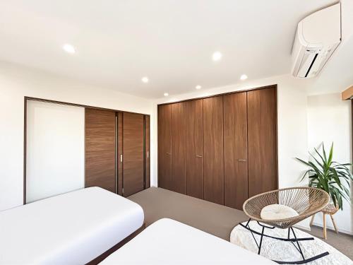 a bedroom with a bed and a chair at Ansou house 大阪ドーム in Osaka