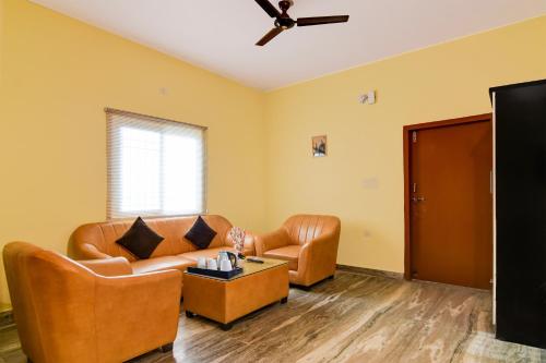 a living room with a couch and two chairs at Super Hotel O Birsa Athletics Stadium Formerly De Anmol Suites in Nāmkom