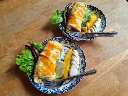 dos platos de comida en una mesa de madera en Twin House, en Luang Prabang