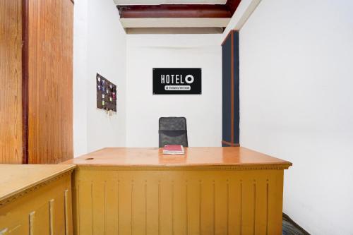 a yellow counter in a room with a sign on the wall at Super Hotel O Pathanamthitta Near Mahatma Gandhi Statue in Pathanāmthitta