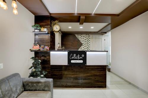 a lobby with a counter with a clock on a wall at Super Collection O Palampur Surat Formerly Hotel Royal Paradise in Bhatha