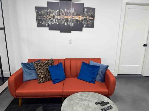 an orange couch with blue pillows in a living room at Downtown New 3 Story Sleeps 14 in Baton Rouge