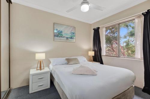 a bedroom with a white bed and a window at Coastal Haven Sandcastles 220 in Coffs Harbour