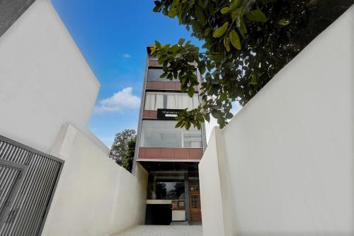 an external view of a building with white walls at Super Townhouse Varanasi City Station Formerly S Kumar Inn in Varanasi