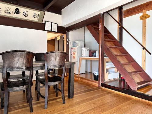 una sala da pranzo con tavolo, sedie e scala di Kokuwaan - Vacation STAY 69575v a Nagahama