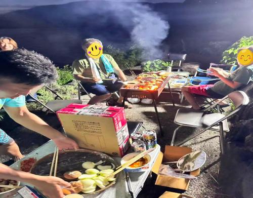 un gruppo di persone sedute attorno a una griglia con una scatola di Kokuwaan - Vacation STAY 69575v a Nagahama