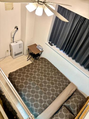 a bed in a room with a window at KIYAZA Road Sapporo in Sapporo