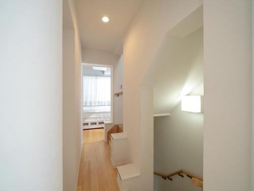 a hallway of a house with white walls at さくら旅館阿佐谷北千利休 in Tokyo