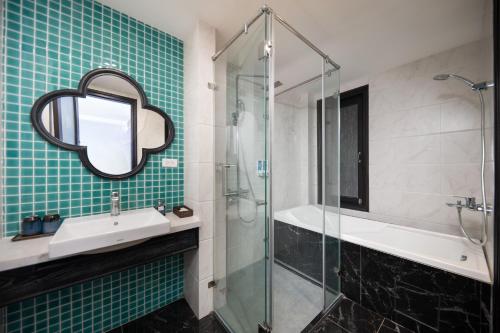 a bathroom with a sink and a glass shower at Hanoi Indochine Premium Hotel in Hanoi