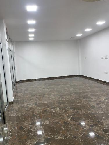 an empty room with a marble floor and white walls at The Meraki Inn in Lucknow