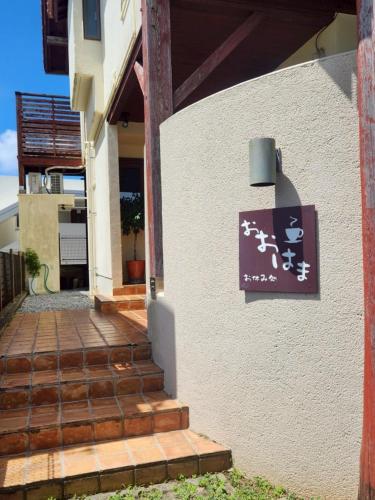 a sign on the side of a building with stairs at お休み処おおはま in Yomitan