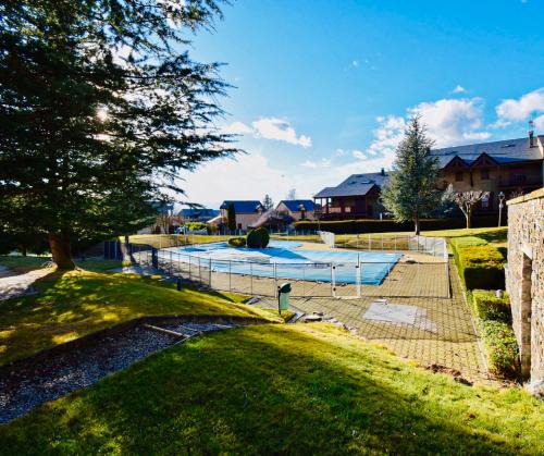 a swimming pool in a yard next to a house at Refugi La Cerdanya, Ski and Pool La Cerdaña in Bourg-Madame