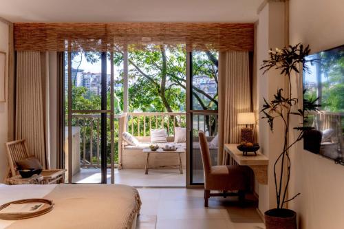 a bedroom with a bed and a view of a balcony at Wanan Tinglan Wild Luxury Resort Designer Hotel in Jinghong