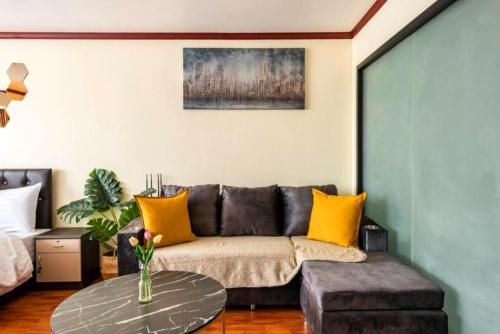 a living room with a couch and a table at SelfCheckIn Omni Tower Sukhumvit4 NaNa Asoke BTS MRT Hispeed WiFi Pool&Gym in Bangkok