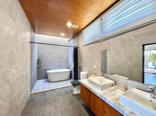 a bathroom with two sinks and a tub and a toilet at 月伴灣海景沙灘民宿 in Beinan