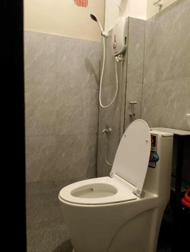 a bathroom with a toilet with the lid up at American Roadhouse Hotel and Restaurant in Candijay