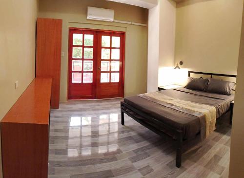 Un dormitorio con una cama y una puerta roja. en American Roadhouse Hotel and Restaurant, en Candijay