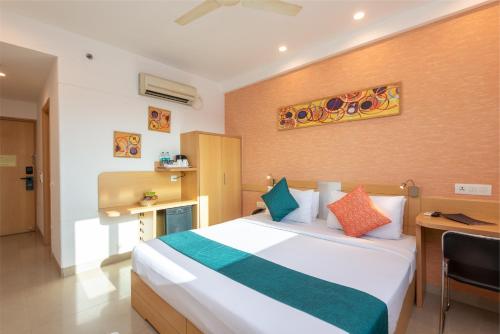 a hotel room with a bed and a desk and a bed at Mango Grove Hotel in Chandīgarh