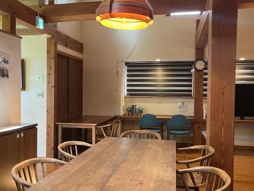 a dining room with a wooden table and chairs at お休み処おおはま in Yomitan