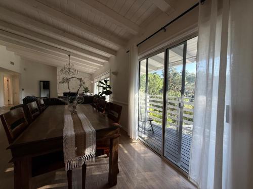 a dining room with a wooden table and a large window at Hillside Hideaway - Private Woodland Hills Canyon Suite in Woodland Hills