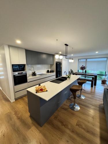 a kitchen with a island in the middle of a room at Green Hill Views - Family Home close to Hobart in Rokeby