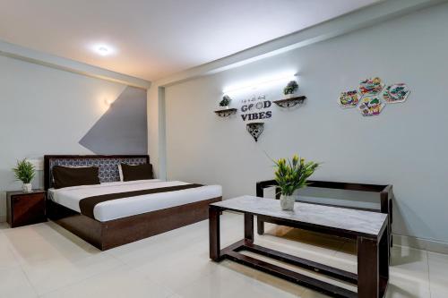 Un dormitorio con una cama y una mesa dentro. en Hotel O Dadri Main Road Greater Noida, en Greater Noida