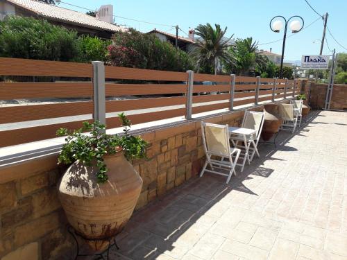 a row of chairs and a wall with a fence at Plaka Studios in Karfas