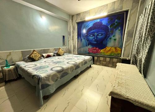 a bedroom with a bed with a painting on the wall at Mato Shree Aashray Homestay in Gaya