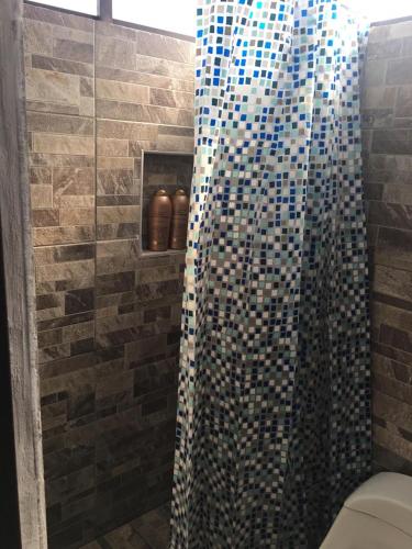 a bathroom with a shower with a mosaic shower curtain at Suite La Lomita #1 Climatizada Zona Dorada Tuxtla in Tuxtla Gutiérrez
