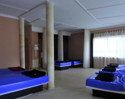 a room with blue beds and pillars in it at Haus Andreas - Ferienwohnungen in Turracher Hohe