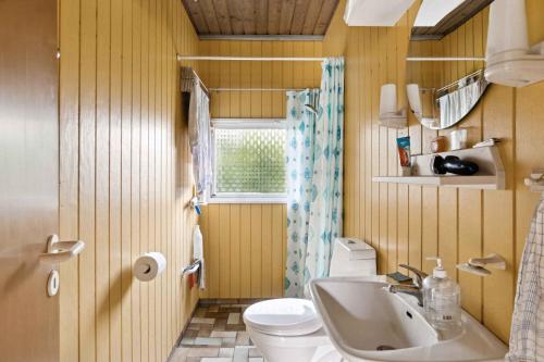 une salle de bain avec un lavabo et des toilettes et une fenêtre dans l'établissement Charming Cottage Near The Water, à Kisserup