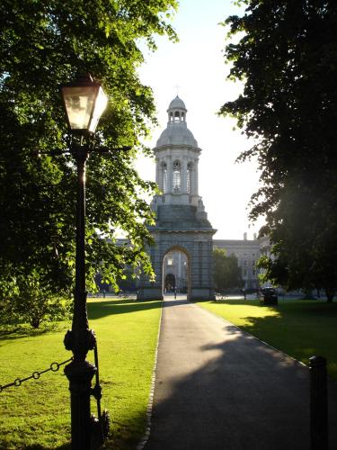 a street light in front of a building with a tower at Trinity College - Campus Accommodation in Dublin
