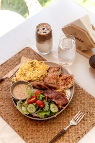 a plate of food with meat and vegetables on a table at Wanan Tinglan Wild Luxury Resort Designer Hotel in Jinghong