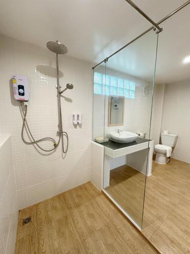a bathroom with a shower and a sink and a toilet at De Hom Hotel Mae Hong Son in Mae Hong Son
