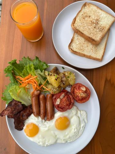 De Hom Hotel Mae Hong Son في ماي هونغ سون: طبقين من طعام الإفطار مع البيض والخبز المحمص