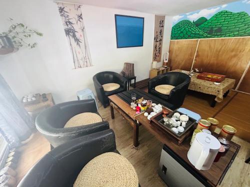 a living room with a couch and a table at The Cave - Adults Only in Tanah Rata